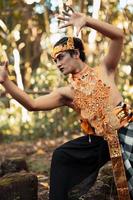 danza posa a partire dal un' pauroso balinese uomo con un' d'oro collana e corona su sua corpo A petto nudo foto