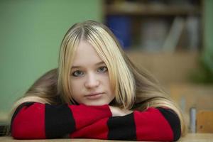 alto scuola alunno. triste occhi azzurri adolescente ragazza sembra a il telecamera. foto