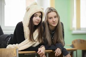 Due amiche adolescenziale ragazze in posa e guardare a il telecamera. il ragazze siamo quindici anni vecchio. anziano studenti. foto