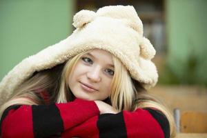 alto scuola alunno. triste occhi azzurri adolescenziale ragazza nel un' pelliccia cappello con orecchie. foto