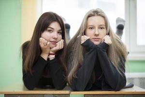 Due amiche adolescenziale ragazze in posa e guardare a il telecamera. il ragazze siamo quindici anni vecchio. anziano studenti. foto