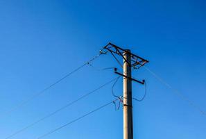 elettrico polo con un' lineare filo contro il blu cielo avvicinamento. energia elettrico polo. foto