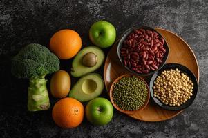 legumi e frutta su fondo scuro foto