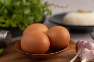tre uova di gallina su un piatto con aglio foto