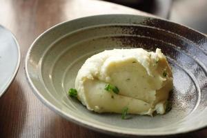 purè di patate in una ciotola su tavola rustica in legno foto