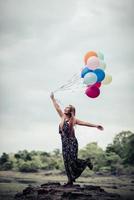 giovane donna che tiene palloncini colorati in natura foto
