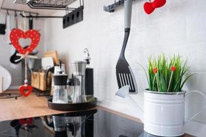 il interno di il cucina nel il Casa è decorato con rosso cuori per San Valentino giorno. arredamento su il tavolo, fornello, utensili, festivo umore nel un' famiglia nido foto