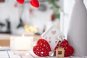 chiave per Casa di accogliente casa con San Valentino arredamento su tavolo di cucina. regalo per san valentino giorno, famiglia amore nido. costruzione, disegno, progetto, in movimento per nuovo Casa, mutuo, affitto e Acquista vero tenuta foto