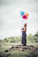 giovane donna che tiene palloncini colorati in natura foto