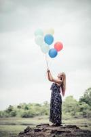 giovane donna che tiene palloncini colorati in natura foto