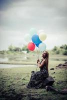 giovane donna che tiene palloncini colorati in natura foto