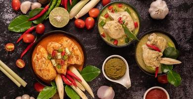 pollo al curry in una ciotola con lime, pomodori e aglio alla citronella foto