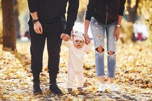 vicino su Visualizza. allegro famiglia avendo divertimento insieme con loro bambino nel bellissimo autunno parco foto