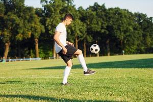 giovane calcio giocatore avere formazione su il allegro campo foto