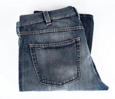 piegato blu Uomini jeans su un' bianca sfondo foto