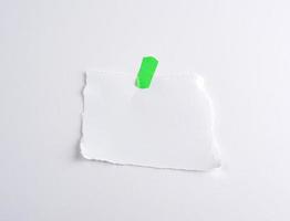 strappato via bianca pezzo di carta incollato per verde velcro foto