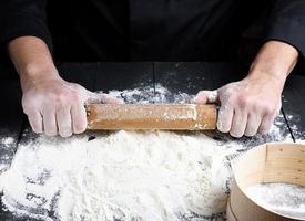 di legno rotolamento perno nel Uomini mani e bianca Grano Farina foto