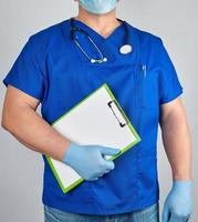 medico nel blu uniforme e sterile latice guanti detiene appunti foto