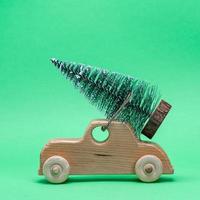 di legno giocattolo auto trasporto un' festivo albero su il tetto foto