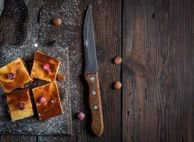 pezzi di torta di formaggio con zucca su Marrone di legno taglio tavola foto
