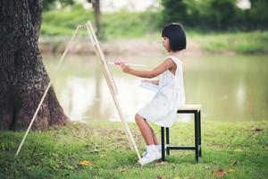 artista della bambina che dipinge un quadro nel parco foto