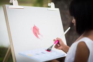 artista della bambina che dipinge un quadro nel parco foto