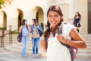 carino ispanico adolescente ragazza alunno a piedi su scuola città universitaria foto