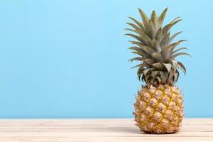 ananas su un tavolo con sfondo blu foto