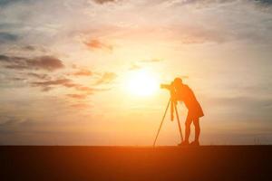 sagoma di un fotografo che scatta al tramonto foto