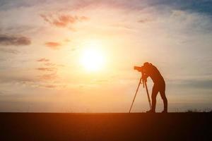 sagoma di un fotografo che scatta al tramonto foto