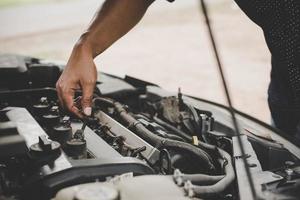 uomo che controlla un motore di automobile foto