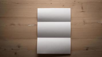carta piegata in bianco bianca sulla tavola di legno foto