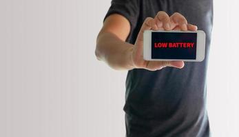 uomo che mostra il telefono con batteria scarica sullo schermo foto