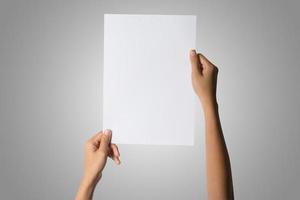 primo piano della mano di una donna che tiene carta bianca isolato su sfondo bianco foto