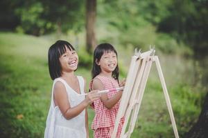 due pittori di bambina che disegnano arte nel parco foto