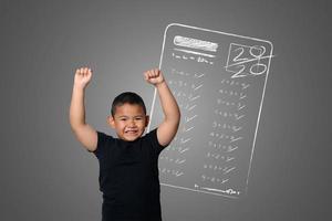 giovane ragazzo mostra il massimo dei voti nei test scolastici sulla lavagna foto