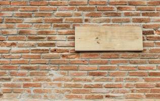 segno di legno sul muro di mattoni foto