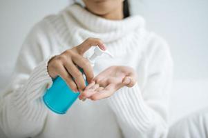 giovane donna utilizzando gel per il lavaggio delle mani foto