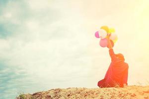 ragazza adolescente con palloncini colorati nel cielo luminoso foto