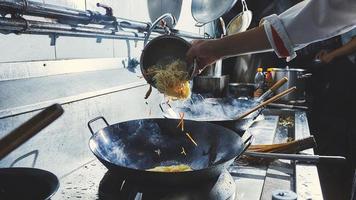 chef che cucina il cibo nel wok foto