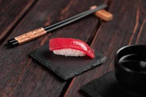 delizioso Sushi maguro tonno. nigiri con tonno su nero e di legno sfondo . tradizionale giapponese cucina foto