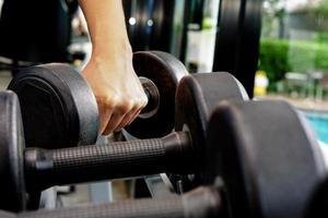 vicino su di mano Tenere manubrio nel fitness. esercizio e Salute cura concetto. foto