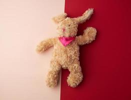 giocattolo Marrone felpa lepre bugie su un' rosa sfondo foto