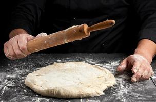 bianca Grano Farina il giro Impasto e di legno rotolamento perno nel maschio mani foto