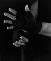 uomo impacchi il suo mani nel nero tessile bendare per gli sport foto