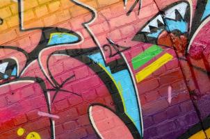 astratto colorato frammento di graffiti dipinti su vecchio mattone parete. strada arte composizione con parti di non scritto lettere e multicolore macchie. subculturale sfondo struttura foto