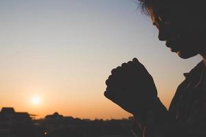giovane donna che prega con la mano, concetto di preghiera per fede, spiritualità e religione foto