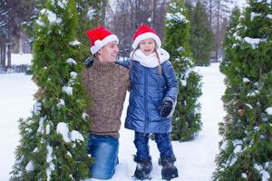 adorabile poco ragazza e contento papà nel Santa cappelli all'aperto foto