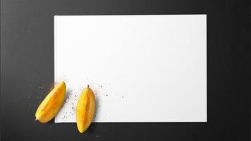 fette di mango con spezie su carta bianca su sfondo nero foto