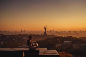 donna fare yoga su il tetto di un' grattacielo nel grande città. foto